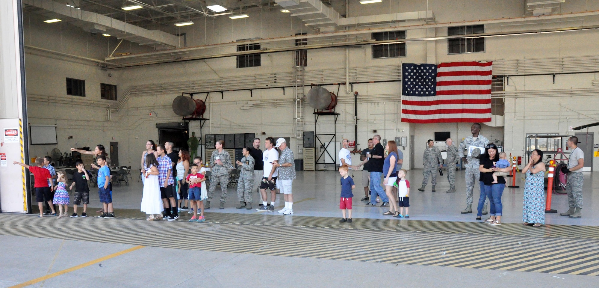 Members of the 943rd Rescue Group and families of 306th Rescue Squadron Reserve Airmen wait for the arrival of returning deployers at Davis-Monthan Air Force Base June 2 The 306th RQS is part of the 943rd Rescue Group, the Air Force Reserve Command's premier combat search and rescue group, and had been deployed to the Horn of Africa for four months. The team saved six lives during the deployment, flew more than 500 combat hours, conducted 67 parachute deployments, and provided more than 2,600 hours of dedicated alert coverage. (U.S. Air Force photo/Master Sgt. Greg Gaunt)