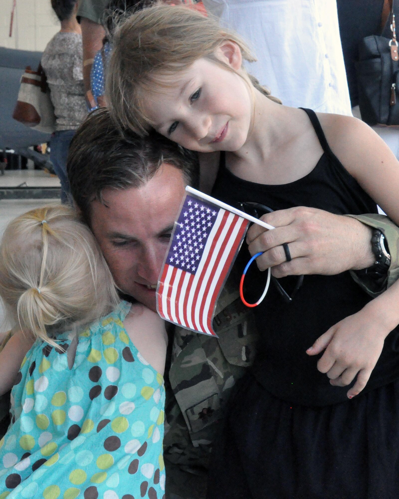 A combat rescue officer from the 306th Rescue Squadron hugs his daughters upon his return to Davis-Monthan Air Force Base, Ariz., from the Horn of Africa June 2. The 306th RQS is part of the 943rd Rescue Group, the Air Force Reserve Command's premier combat search and rescue group. They were deployed for four months and saved six lives during the deployment, flew more than 500 combat hours, conducted 67 parachute deployments, and provided more than 2,600 hours of dedicated alert coverage. (U.S. Air Force photo/Master Sgt. Greg Gaunt)