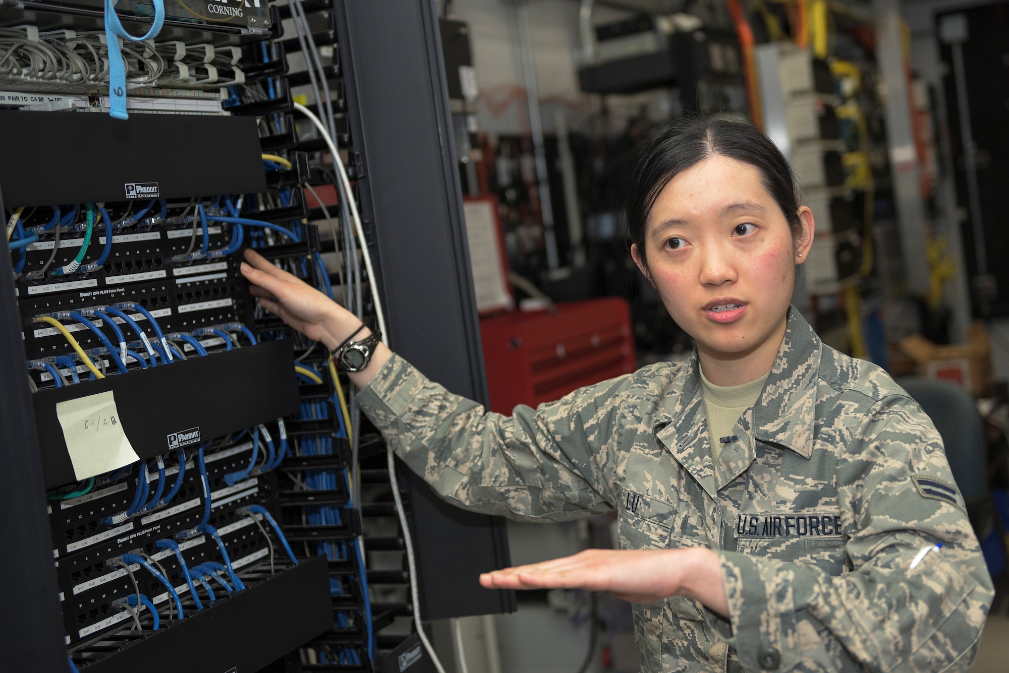 U.S. Air Force Airman 1st Class Irene Lu, a cyber transport systems specialist with the 182nd Communications Flight, Illinois Air National Guard, explains how a network patch panel operates in Peoria, Ill., April 30, 2016. Lu, a first-generation American of Chinese heritage and the only female in her shop, said that the more diversity the military has, the more one person can learn about the world and learn from different experiences. (U.S. Air National Guard photo by Staff Sgt. Lealan Buehrer)