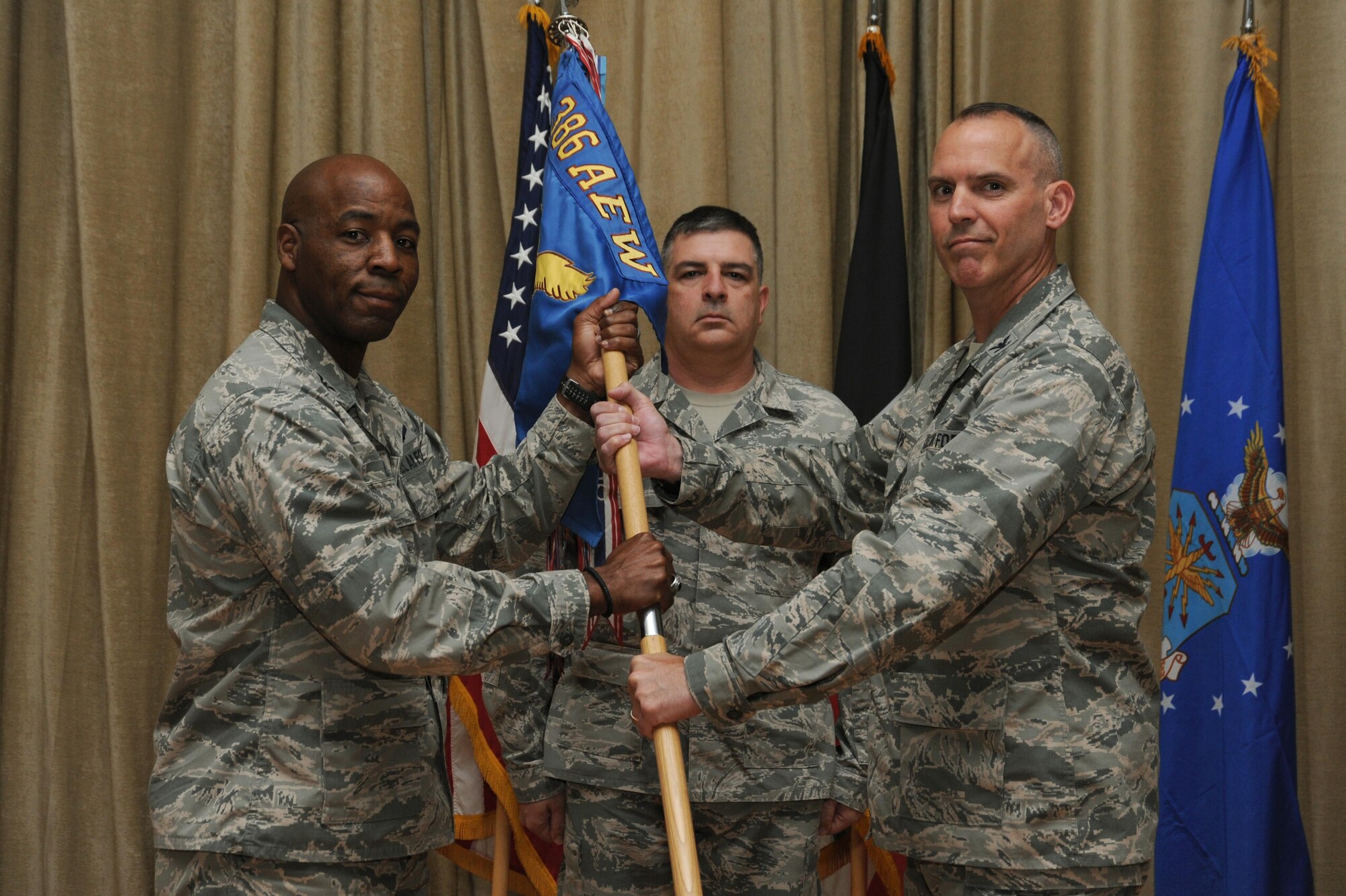 Col. William Phillips assumes command of the 386th Expeditionary Maintenance Group and receives the guidon from Col. Clarence Lukes Jr., 386th Air Expeditionary Wing commander, during a change of command ceremony at an undisclosed location in Southwest Asia June 3, 2016. Prior to assuming command of the 386 EMXG, Phillips served as the deputy commander of the 43rd Airlift Group at Pope Army Airfield, Fort Bragg, N.C.  Phillips will be commanding a group of Airmen responsible for aircraft maintenance support for C-130 Hercules, EC-130 Hercules, MQ-9 Reaper, and MQ-1 Predator aircraft assigned to the 386 AEW to conduct missions throughout the U.S. Central Command area of responsibility. (U.S. Air Force photo by Senior Airman Zachary Kee)