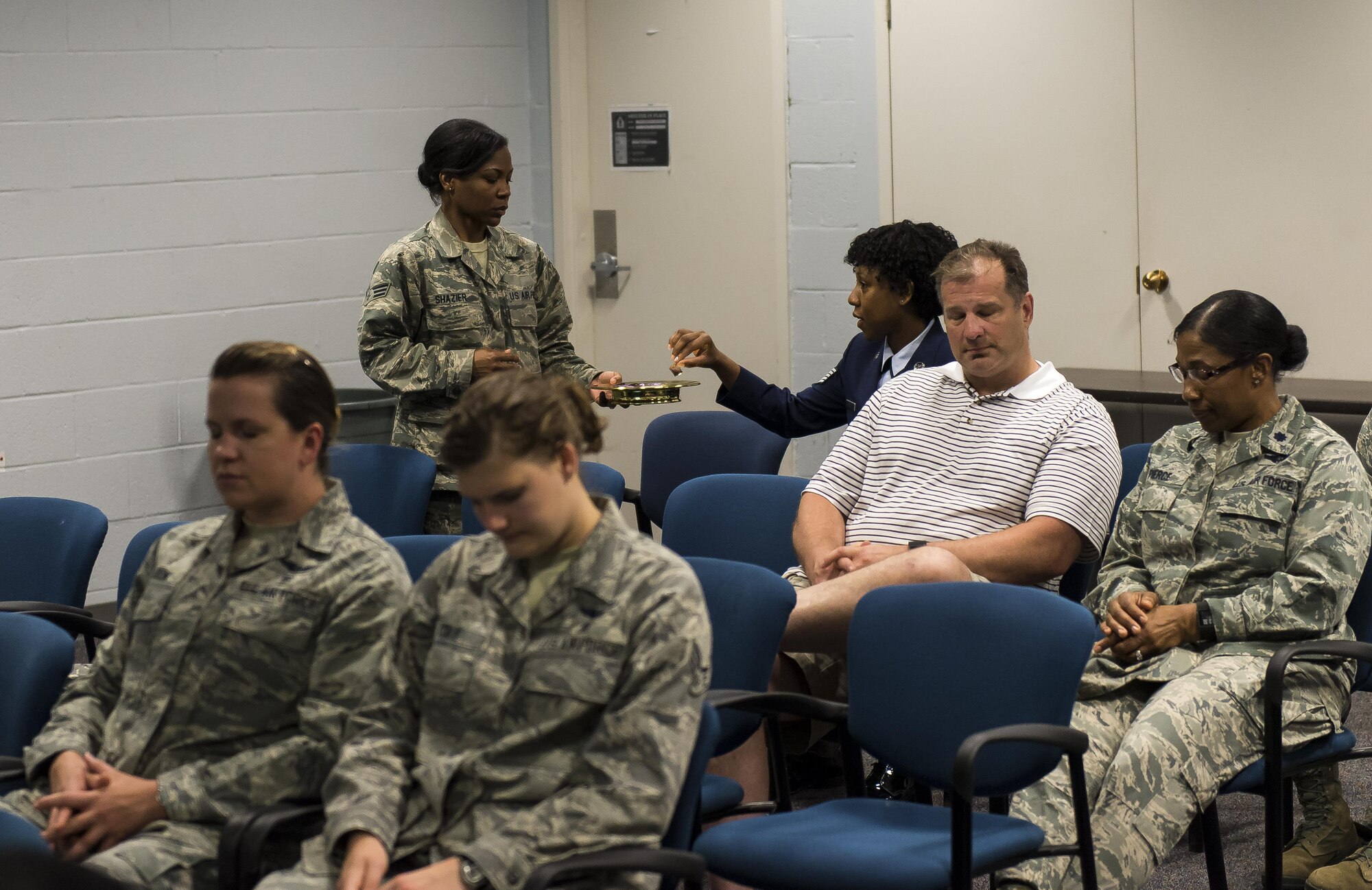 Senior Airman Jenny Shazier, chaplains’ assistant for the 459th Air Refueling Wing, hands out the sacrament while attendees pray during the Protestant service June 5 on Joint Base Andrews, Maryland. The 459th ARW chaplain team won the 2015 Air Force Reserve Command Outstanding Chaplain Corps Program team award for its work throughout the year. (U.S. Air Force/SSgt Scott Pauley)