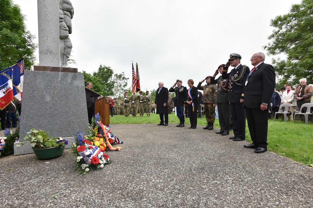 Service members, veterans and government officials participate in a D-Day remembrance ceremony for the 507th Parachute Infantry Regiment, 82nd Airborne Division, in Amfreville, France, June 4, 2016.  The paratrooper in the statue represents Pvt. Joe Gandara, a 2nd Squadron, 507th Parachute Infantry Regiment Paratrooper during World War II who was posthumously awarded the Medal of Honor in 2014 for single handedly destroying three enemy machine guns before he was fatally wounded. Army photo by Sgt. 1st Class Crista Mary Mack