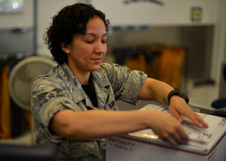 Senior Airman Justine Davis, 51st Communications Squadron finance clerk, places a shipping label on a package at Osan Air Base, Republic of Korea, June 3, 2016. Members of Team Osan take advantage of the post office to send gifts and other personal items back to the United States under the watchful eyes of 51st CS Airmen. (U.S. Air Force photo by Senior Airman Victor J. Caputo/Released)