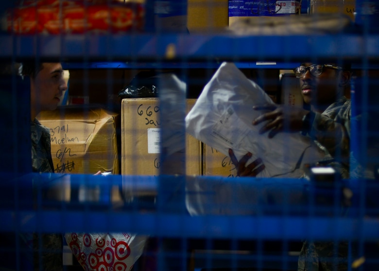 Airmen 1st Class Carmine Carletto, left, and Travon McCall, 51st Communications Squadron postal clerks, sort through a bin of packages at Osan Air Base, Republic of Korea, June 3, 2016. All packages sent to the base are individually tracked and sorted to ensure each item reaches its proper destination on base. (U.S. Air Force photo by Senior Airman Victor J. Caputo/Released)