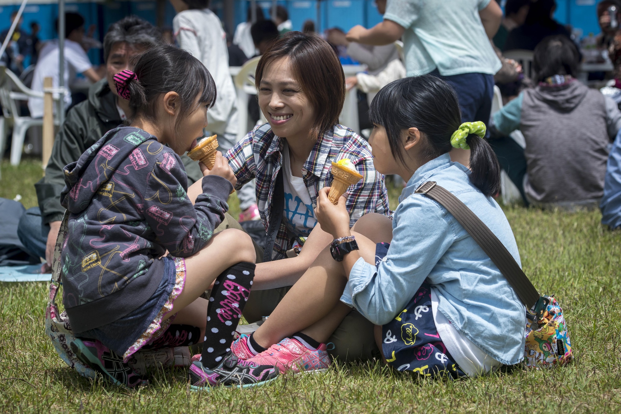 A Japanese mother and her two daughters enjoy ice cream cones during the 28th Annual American Day in Misawa City, Japan, June 5, 2016. Showcasing the region’s bilateral partnership among U.S. military and Japanese residents, more than 80,000 annual attendees interacted with volunteers from private base organizations at various American-based food booths sharing a taste of home. Americans and Japanese residents also participated in activities such as a family fun run, an American-themed parade, sports tournaments, street performances and a haunted house. (U.S. Air Force photo by Staff Sgt. Benjamin W. Stratton)