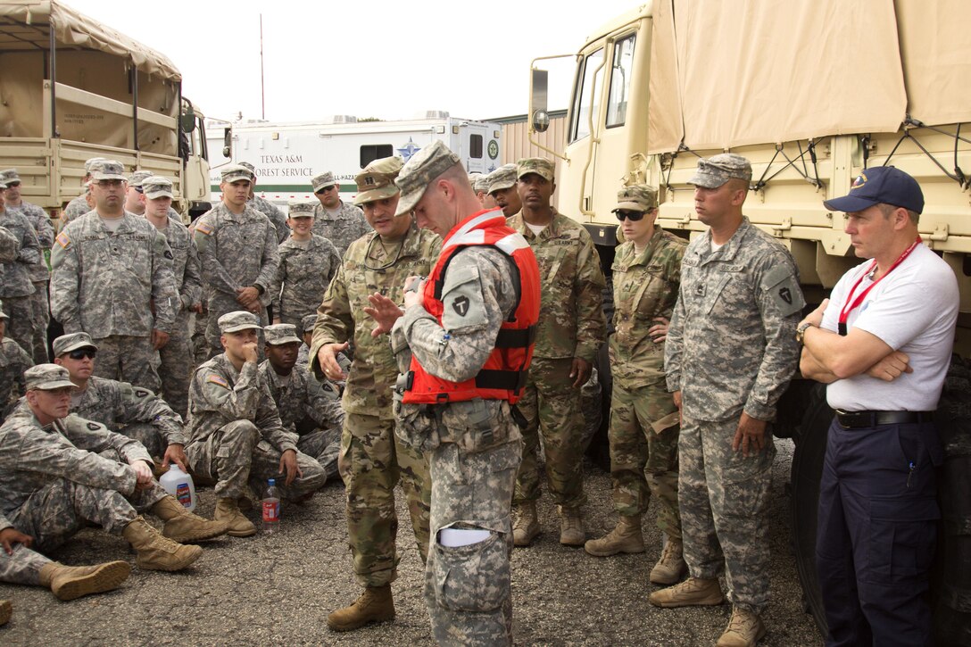 Army Capt. Moya, center left, explains while a soldier demonstrates, the proper wearing of a life jacket before searching for residents following severe flooding in Rosenberg, Texas, June 3, 2016. Moya is assigned to the Texas Army National Guard. Texas Army National Guard photo by Staff Sgt. Timothy Pruitt
