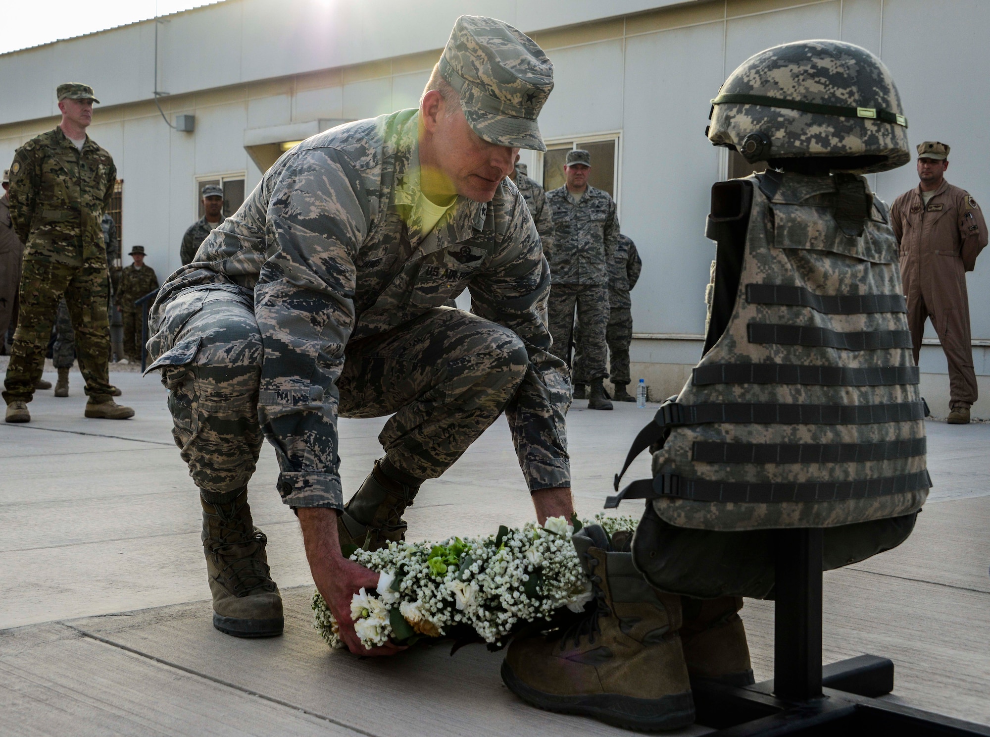 Brig. Gen. Darren V. James, 379th Air Expeditionary Wing commander, places a wreath in front of a battlefield cross during a Memorial Day ceremony May 30, 2016, at Al Udeid Air Base, Qatar. The floral tribute is a ritual that occurs around the world. The tradition recognizes the beauty and the brevity of life for those who died while serving in the military. (U.S. Air Force photo/Senior Airman Janelle Patiño/Released)