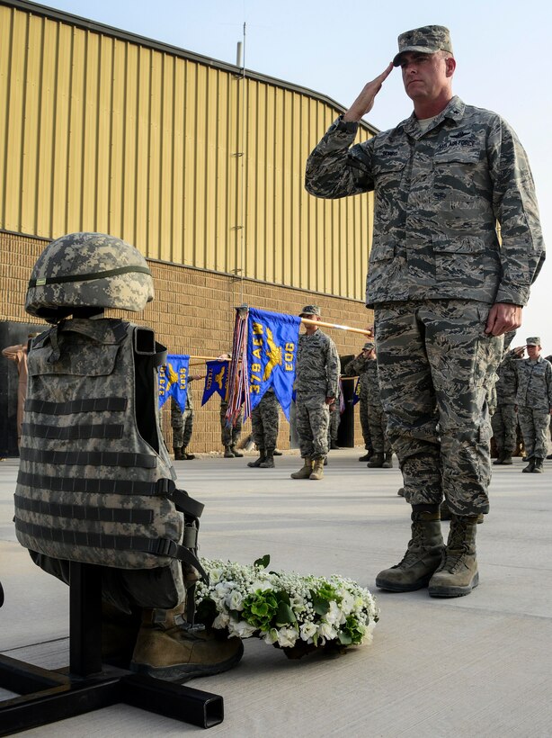 Brig. Gen. Darren V. James, 379th Air Expeditionary Wing commander, salutes the ceremonial battlefield cross and wreath during a Memorial Day ceremony May 30, 2016, at Al Udeid Air Base, Qatar. The battlefield cross is comprised of combat gear and serves as a representation to commemorate the men and women who died while serving in the military. (U.S. Air Force photo/Senior Airman Janelle Patiño/Released)