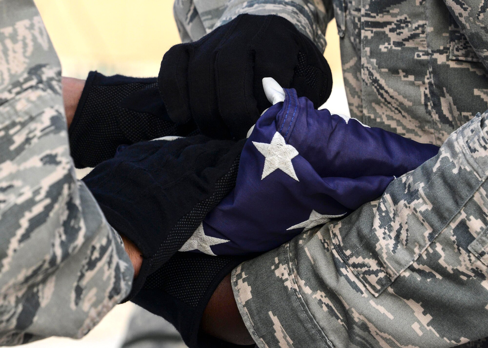 Members of the 379th Air Expeditionary Wing honor guard perform a two-man fold during a Memorial Day ceremony May 30, 2016, at Al Udeid Air Base, Qatar. The base honor guard performs military honors for various events and ceremonies here. The flag is folded into a shape of a tri-cornered hat in representation of the service members who fought for the country to preserve its rights, privileges and freedoms of American citizens. (U.S. Air Force photo/Senior Airman Janelle Patiño/Released)