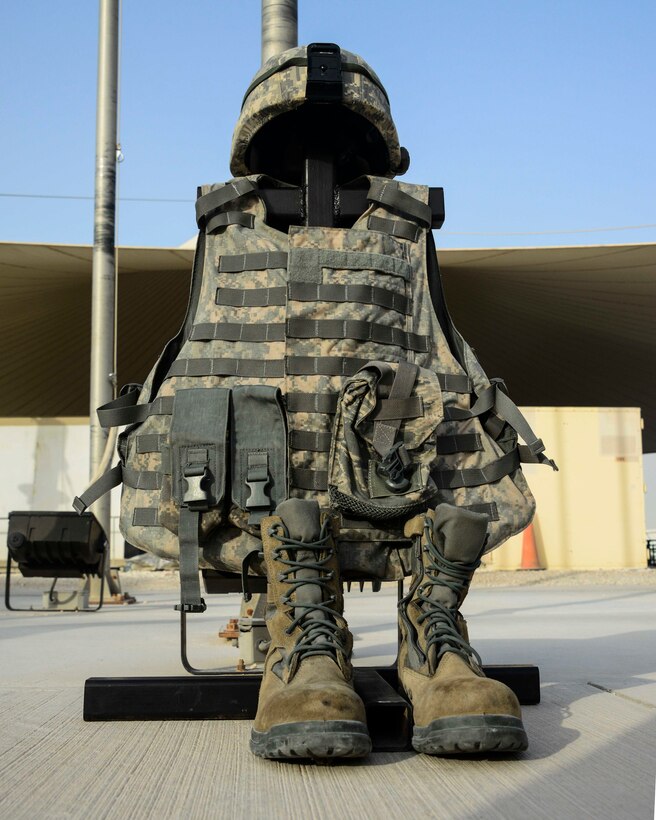 A battlefield cross sits on display in front of 379th Air Expeditionary Wing members during a Memorial Day ceremony May 30, 2016, at Al Udeid Air Base, Qatar. A battlefield cross is a symbolic marker to show honor and respect for service members who have been killed while serving in the military. (U.S. Air Force photo/Senior Airman Janelle Patiño/Released)