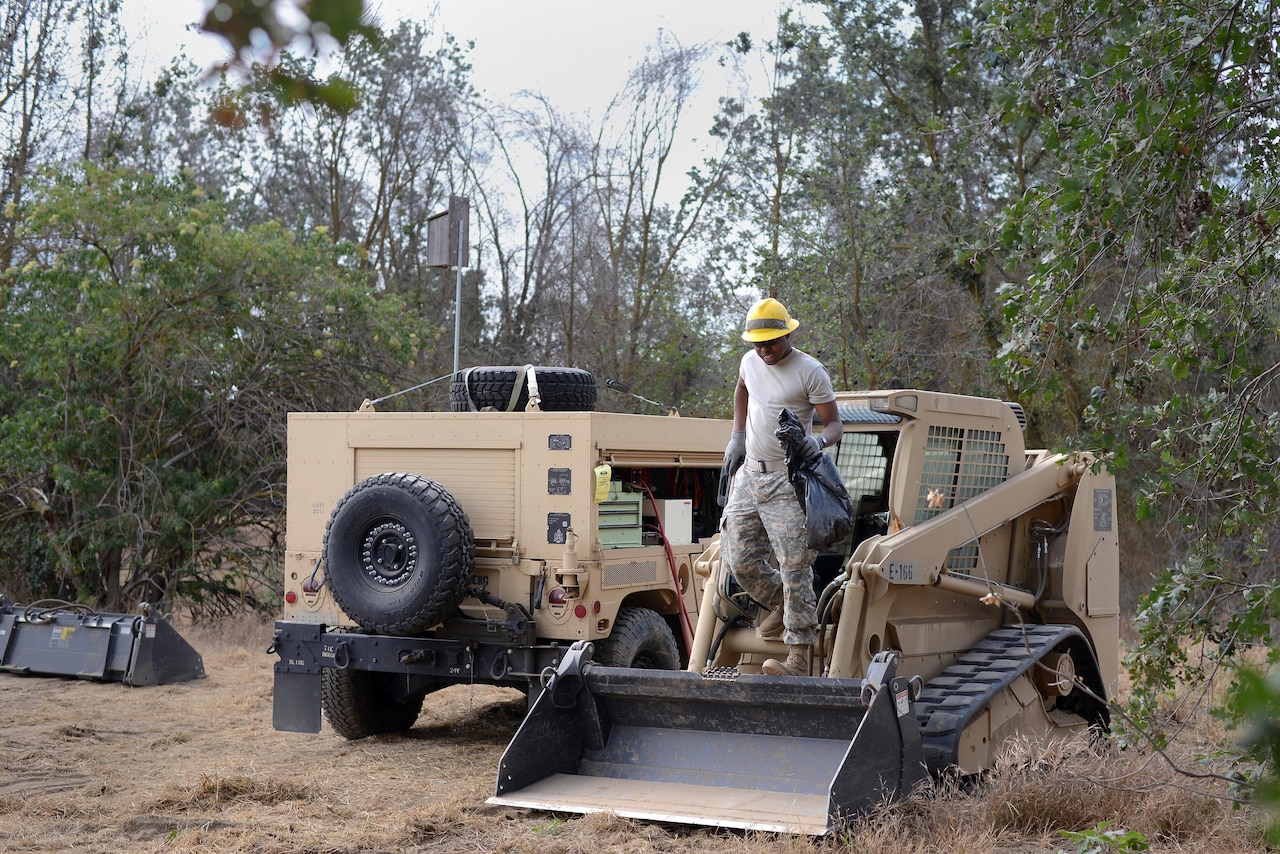 Army Pvt. Rhoen Barnes, a wheeled-vehicle mechanic attached to the Army Reserve’s 672nd Engineer Company, cleans a skid-steer loader in the Kaweah Oaks Preserve at Exeter, Calif., May 24, 2016. Army photo by Sgt. Alfonso Corral