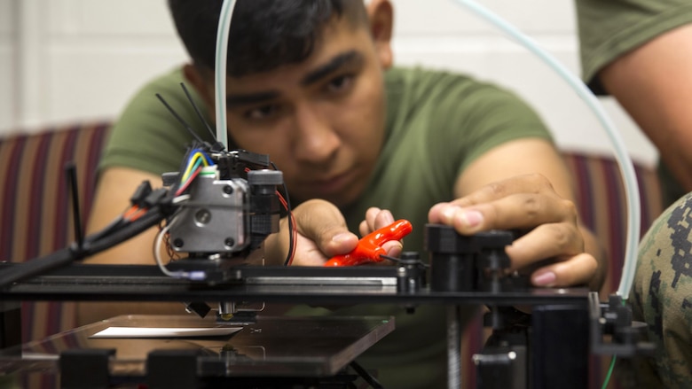 A Marine makes small adjustments to the Invent3D printer before loading a design during a 3D printer class at Marine Corps Base Camp Lejeune, North Carolina, June 2, 2016. Additive manufacturing, or 3D printing, allows Marines to produce parts quickly, with exact specifications and at almost any location. )