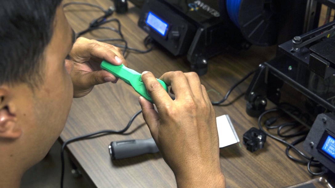 Lance Cpl. Devin Kato, a small arms repair technician with II Marine Headquarters Group, inspects his final product during the 3D printer class at Marine Corps Base Camp Lejeune, North Carolina, June 2, 2016. Additive manufacturing, or 3D printing, allows Marines to produce parts quickly, with exact specifications and at almost any location. 