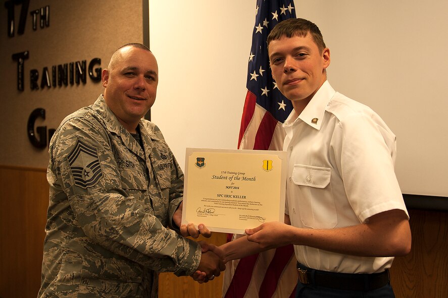 U.S. Air Force Chief Master Sgt. Daniel Stein, 17th Training Group superintendent, presents the 316th Training Squadron Student of the Month award for May 2016 to Army Specialist Eric Keller in Brandenburg Hall on Goodfellow Air Force Base, Texas, June 3, 2016. (U.S. Air Force photo by Airman 1st Class Caelynn Ferguson/Released)