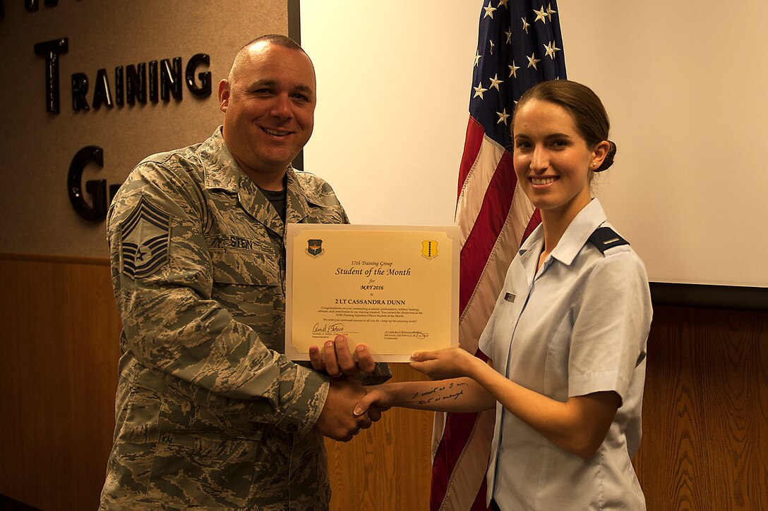 U.S. Air Force Chief Master Sgt. Daniel Stein, 17th Training Group superintendent, presents the 315th Training Squadron Officer Student of the Month award for May 2016 to 1st Lt. Cassandra Dunn in Brandenburg Hall on Goodfellow Air Force Base, Texas, June 3, 2016. (U.S. Air Force photo by Airman 1st Class Caelynn Ferguson/Released)