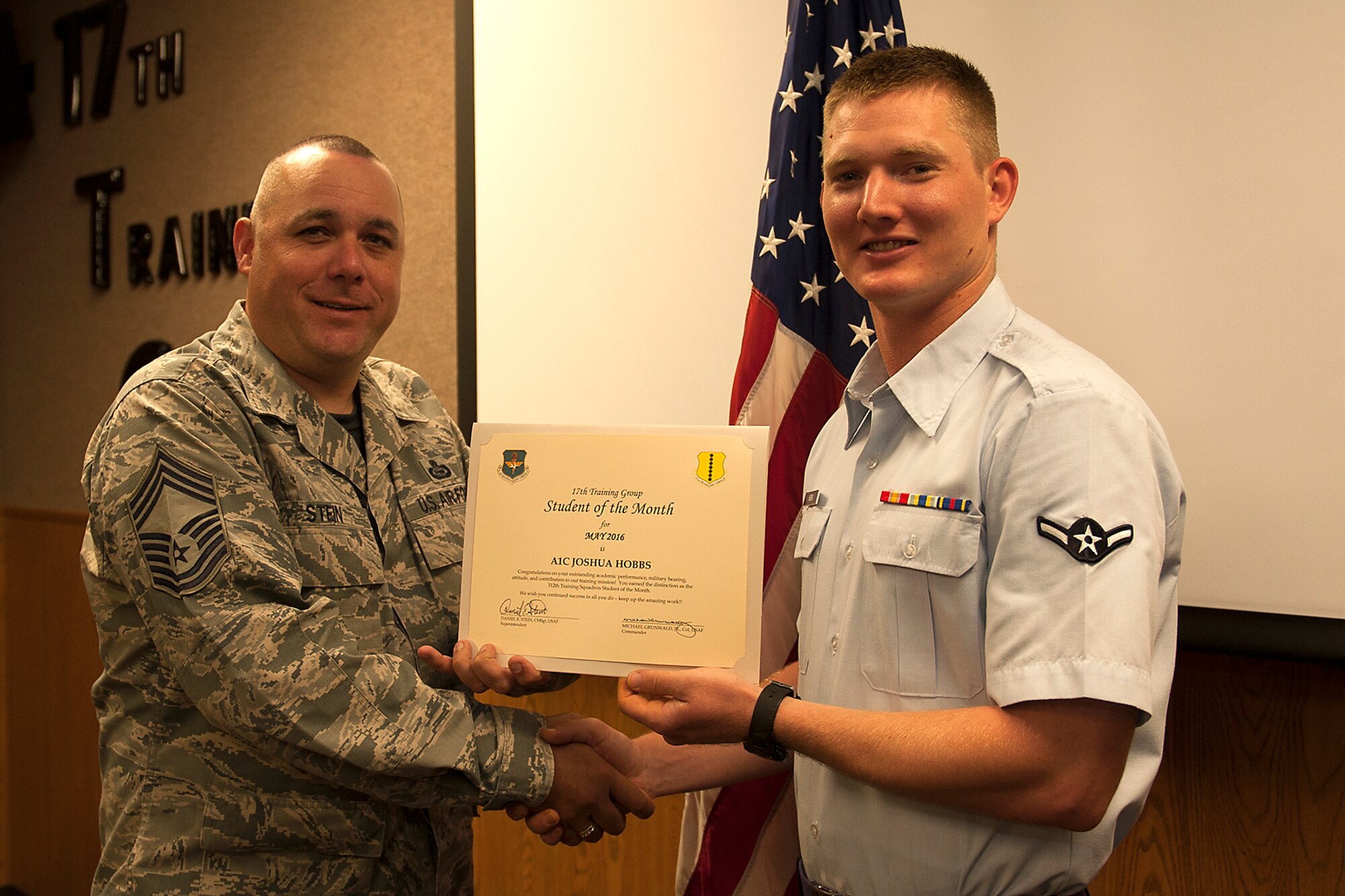 U.S. Air Force Chief Master Sgt. Daniel Stein, 17th Training Group superintendent, presents the 312th Training Squadron Student of the Month award for May 2016 to Airman 1st Class Joshua Hobbs in Brandenburg Hall on Goodfellow Air Force Base, Texas, June 3, 2016. (U.S. Air Force photo by Airman 1st Class Caelynn Ferguson/Released)