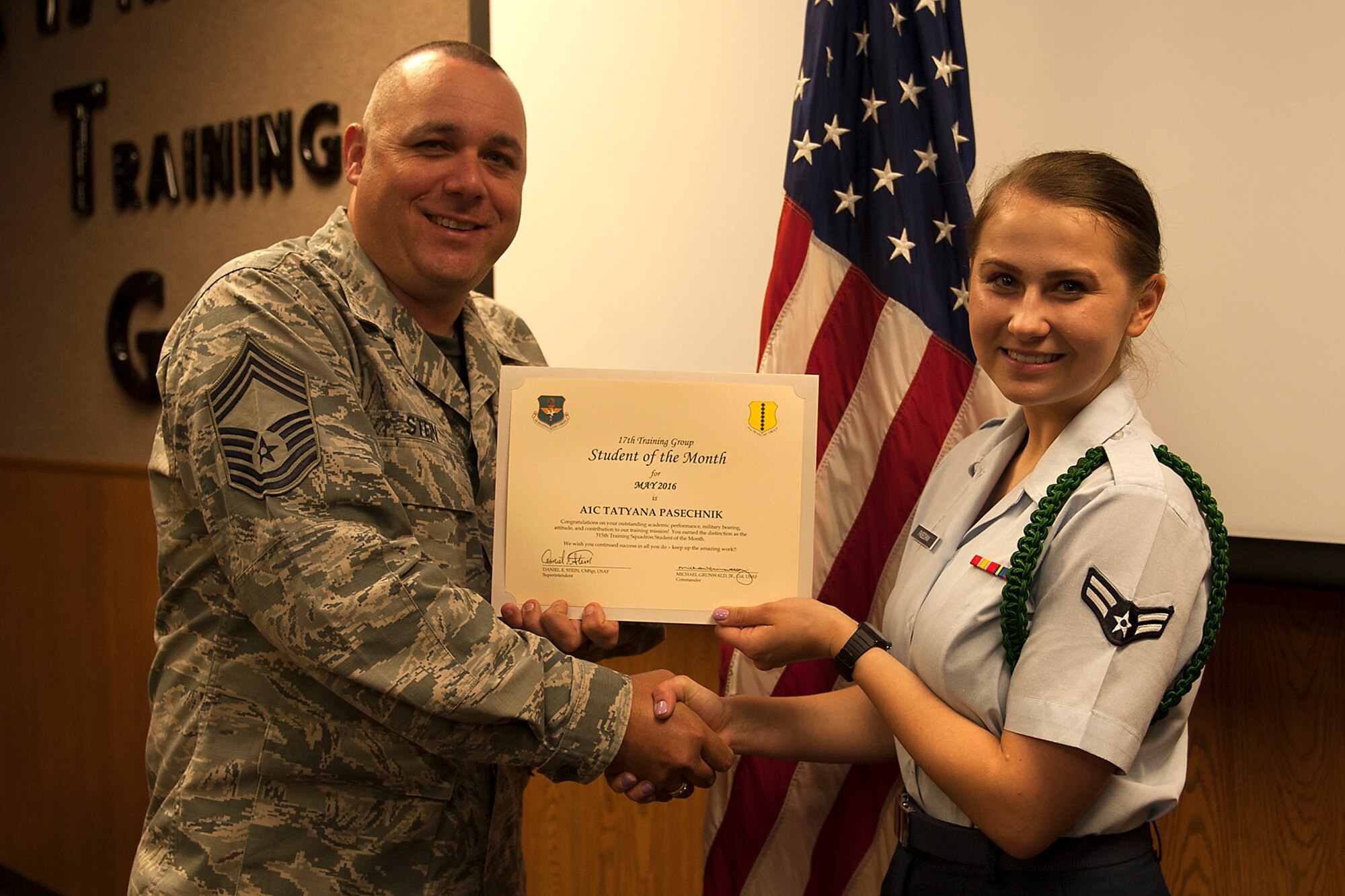 U.S. Air Force Chief Master Sgt. Daniel Stein, 17th Training Group superintendent, presents the 315th Training Squadron Enlisted Student of the Month award for May 2016 to Airman 1st Class Tatyana Pasechnik in Brandenburg Hall on Goodfellow Air Force Base, Texas, June 3, 2016. (U.S. Air Force photo by Airman 1st Class Caelynn Ferguson/Released)