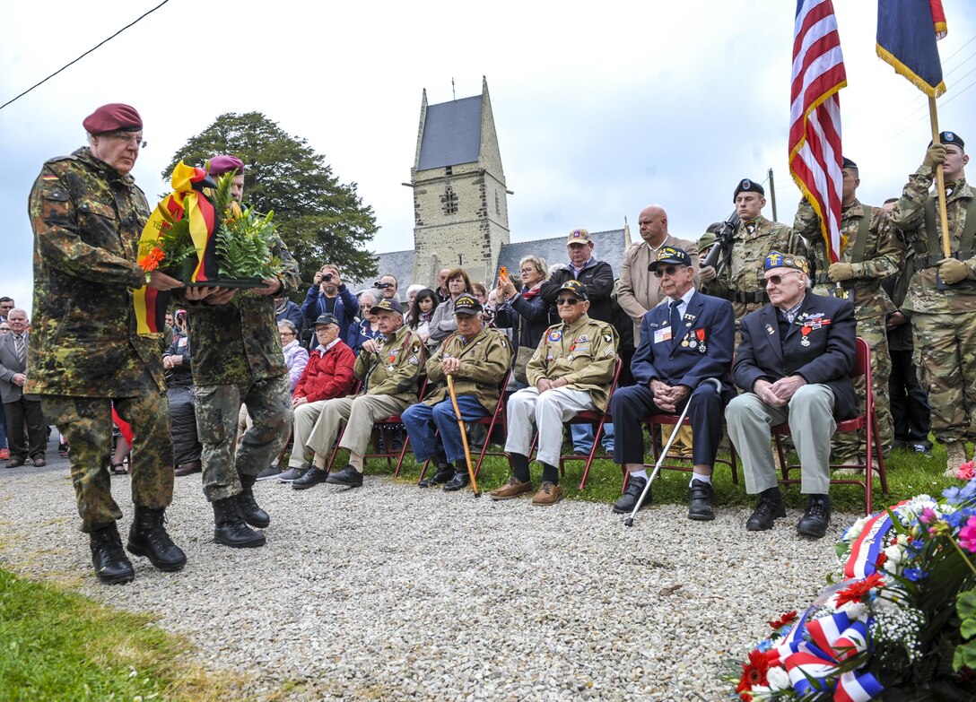 German veterans prepare to lay a wreath at the memorial dedicated to U.S. Army veterans Kenneth Moore and Robert Wright in Angoville au Plain, France, June 4, 2016. Air Force photo by Staff Sgt. Timothy Moore