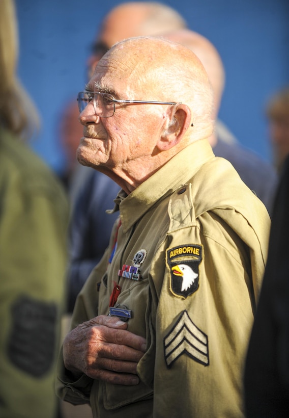 Bob Noody, a World War II veteran, places his hand over his heart during the playing of the American, French and German national anthems during the Liberty Banquet in Sainte Mere Eglise, France, June 4, 2016. Air Force photo by Staff Sgt. Timothy Moore