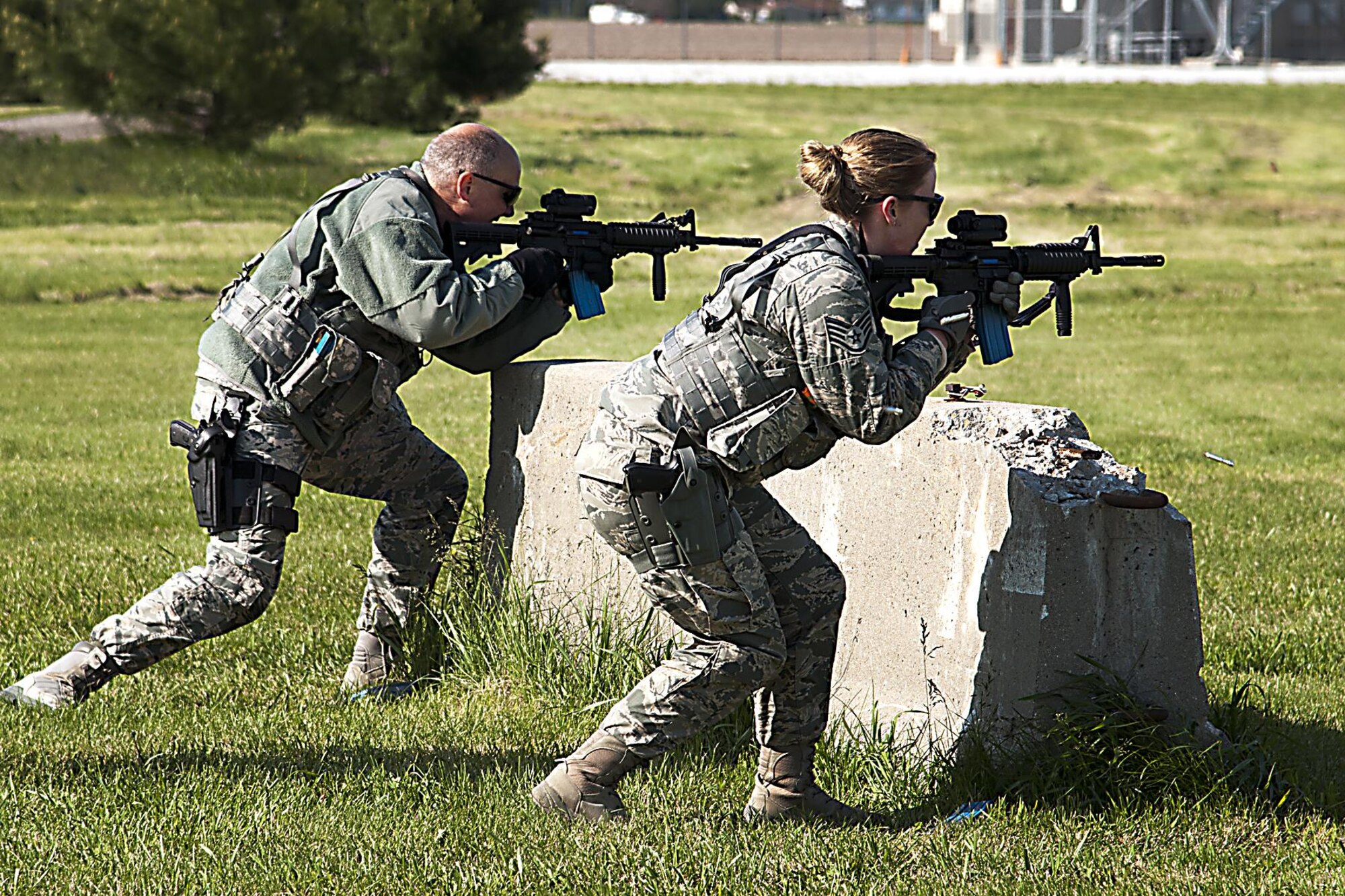 Tech. Sgt. Chris Fancher, 434th Security Forces Squadron fire team leader, and Staff Sgt. Julie Hazelett, 434th SFS fire team member, move from one point of cover to the next during a shoot, move, communicate exercise May 15, 2016 at Grissom Air Reserve Base, Ind. The exercise was part of the SFS members’ mandatory annual firearms qualification. (U.S. Air Force photo/Senior Airman Dakota Bergl)
