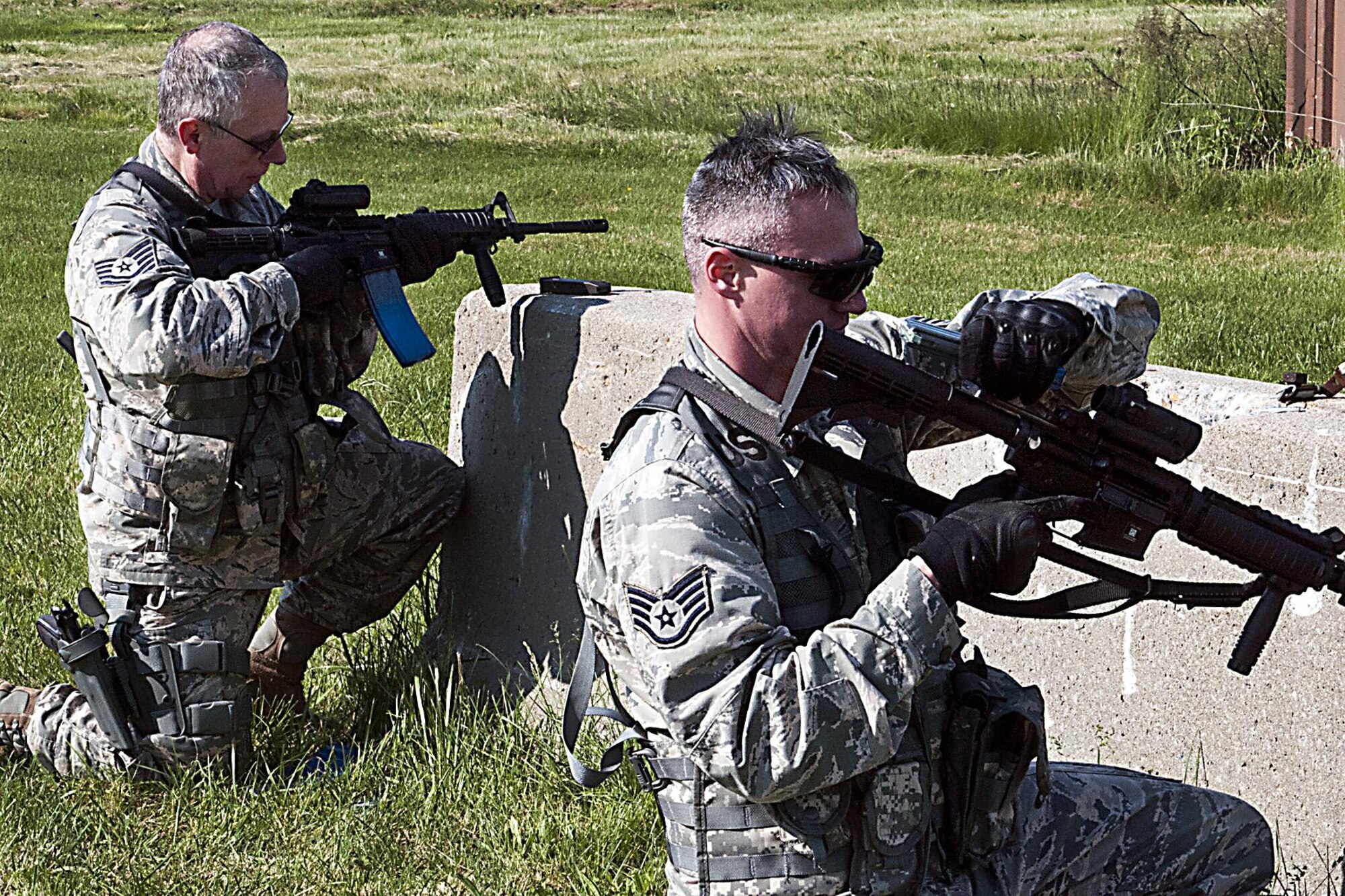 Tech. Sgt. Bruce Bennett, 434th Security Forces Squadron fire team leader, and Staff Sgt. Eric Rosson, 434th SFS fire team member, reload their weapons during a shoot, move, communicate exercise May 15, 2016 at Grissom Air Reserve Base, Ind. The exercise is part of the annual SFS training and focuses on communicating with a squad during a firefight. (U.S. Air Force photo/Senior Airman Dakota Bergl)