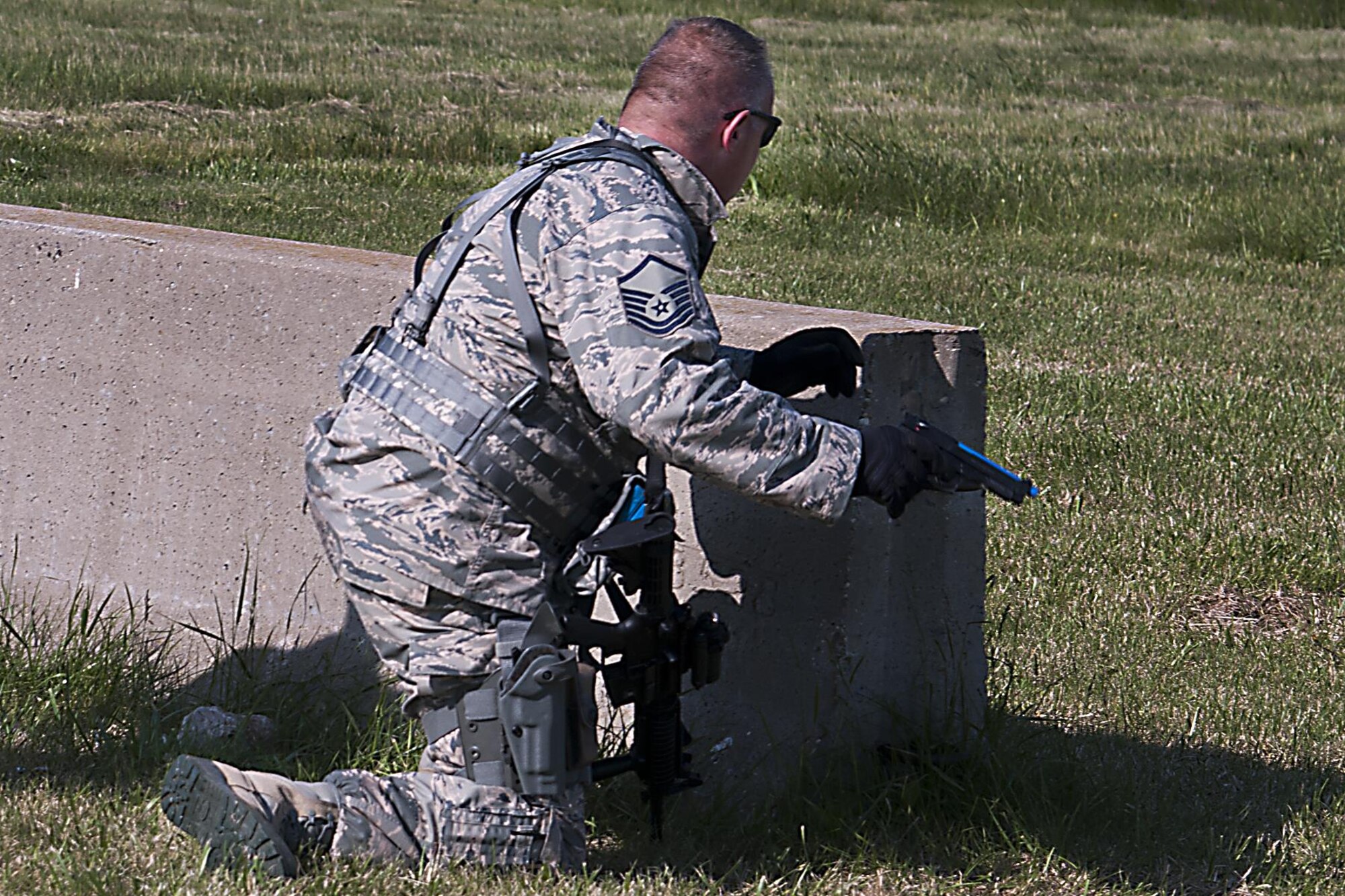 Master Sgt. John Rapp, 434th Security Forces Squadron squad leader, draws his sidearm during a shoot, move, communicate exercise May 15, 2016 at Grissom Air Reserve Base, Ind. Both the M4 rifle and the M9 pistol must be equipped with a special bolt assembly in order to fire the simulated munition rounds. (U.S. Air Force photo/Senior Airman Dakota Bergl) 