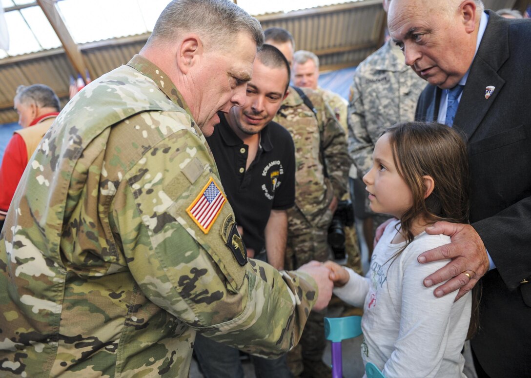 U.S. Army Chief of Staff Gen. Mark A. Milley, left, gives a coin to a French child during the Liberty Banquet in Sainte Mere Eglise, France, June 4, 2016. Air Force photo by Staff Sgt. Timothy Moore