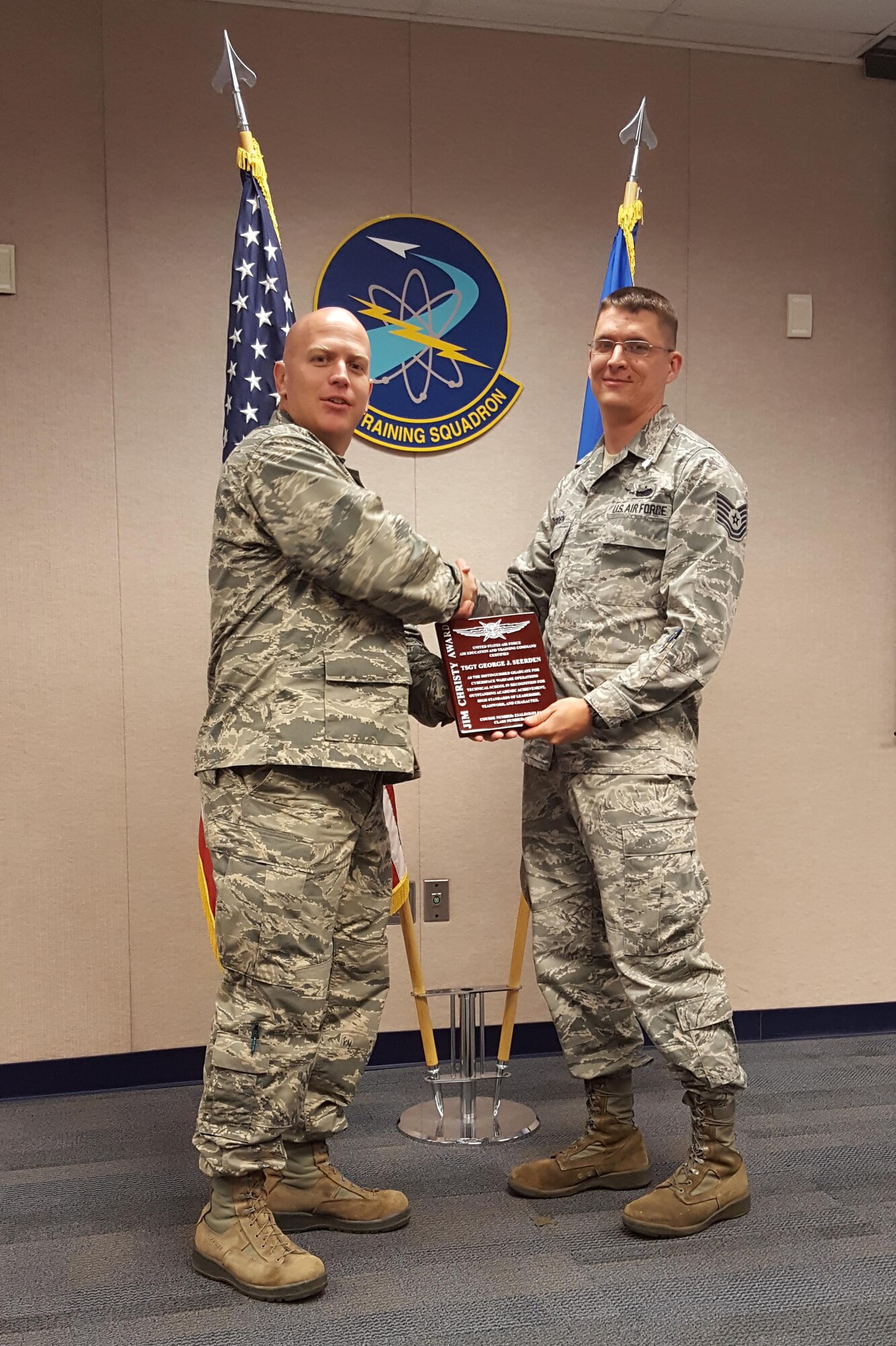 Capt. Ian Chesley, 333rd Training Squadron, presents Tech. Sgt. George Seerden, 960th Cyberspace Operations Group, the Jim Christy Award at the cyber warfare operations technical course  graduation ceremony May 25 at Keesler Air Force Base, Miss. Since it's inception the CWO course has graduated more than 500 students, but not every class has an awardee; Seerden is only the ninth recipient ever. The award recognizes outstanding academic achievement, high standards of leadership, teamwork and character. (U.S. Air Force courtesy photo)      