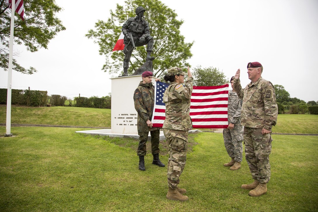 U.S. Army Spc. Tracy McKithern, 982nd Combat Camera Company (Airborne), East Point, Ga., reenlists at the Iron Mike Memorial, La Fiere, Sainte-Mere-Eglise, France, June 3, 2016. (U.S. Army photo by Sgt. Sergio Villafane/Released)