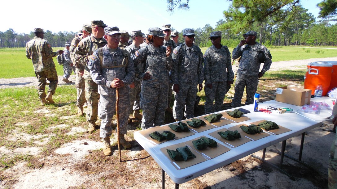 Soldiers assigned to the U.S. Army Reserve Command Augmentation Unit (UAU) line up to receive their compasses, maps and protractors to perform a land navigation and orienteering exercise during their battle assembly on June 4, 2016, at Fort Bragg, N.C. The training involved movement to the training are via U.S. Army Reserve UH-60 Black Hawk helicopters then navigating to fixed points using a compass, map and protractor. The mission of the UAU is to augment United States Army Reserve Command staff during exercises, crisis actions, or a presidential selective reserve call-up. Soldiers of the UAU train regularly to provide the most qualified, trained, and prepared Soldiers upon request by Army units. (U.S. Army photo by Lt. Col. Kristian Sorensen/released)