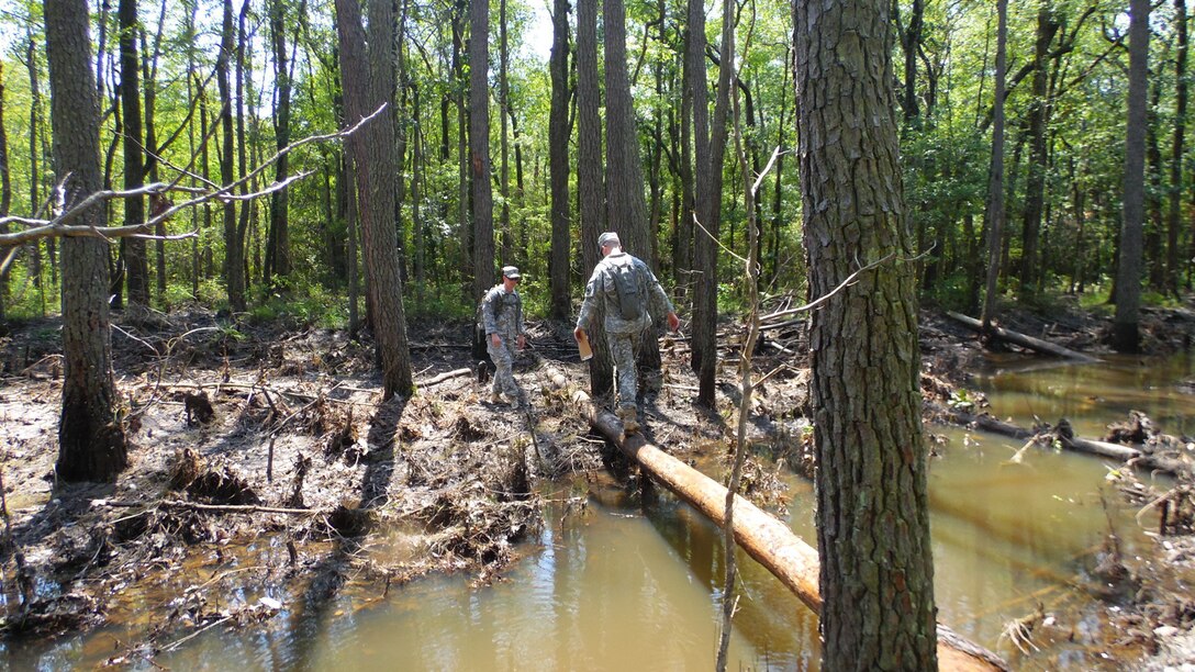 Soldiers assigned to the U.S. Army Reserve Command Augmentation Unit (UAU) cross a water obstacle while attempting to locate one of several points for a land navigation and orienteering exercise during their Battle Assembly on June 4, 2016, at Fort Bragg, N.C. The training involved movement to the training are via U.S. Army Reserve UH-60 Black Hawk helicopters then navigating to fixed points using a map, compass and protractor. The mission of the UAU is to augment United States Army Reserve Command staff during exercises, crisis actions, or a presidential selective reserve call-up. Soldiers of the UAU train regularly to provide the most qualified, trained, and prepared Soldiers upon request by Army units. (U.S. Army Reserve photo by Lt. Col. Kristian Sorensen/released)