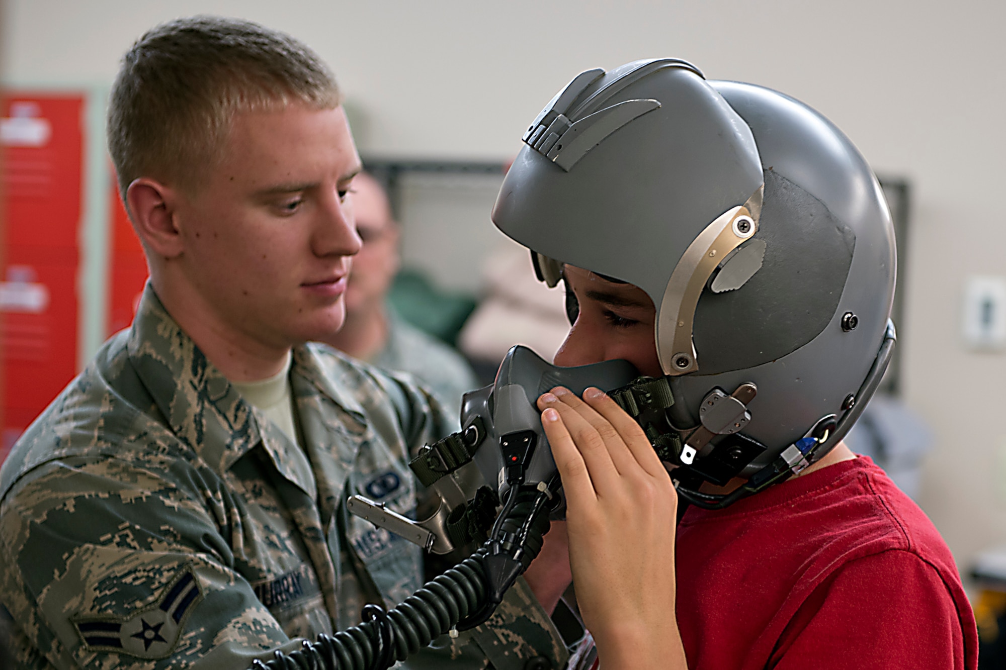 Airman 1st Class Isaac Murray, 434th Aircrew Flight Equipment, helps Ben Beachy, a student at Northwestern Middle School, put on a flight helmet during a tour May 18, 2016 at Grissom Air Reserve Base, Ind. The students were invited to try on helmets and quick don masks during their visit. (U.S. Air Force photo/Senior Airman Dakota Bergl)