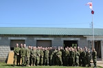 Canadian and American forces gather for a group shot in front of the building the Canadian troops helped to renovate. The troops were here for several weeks as part of a partnership program that offers U.S. and Canada engineers to train together.