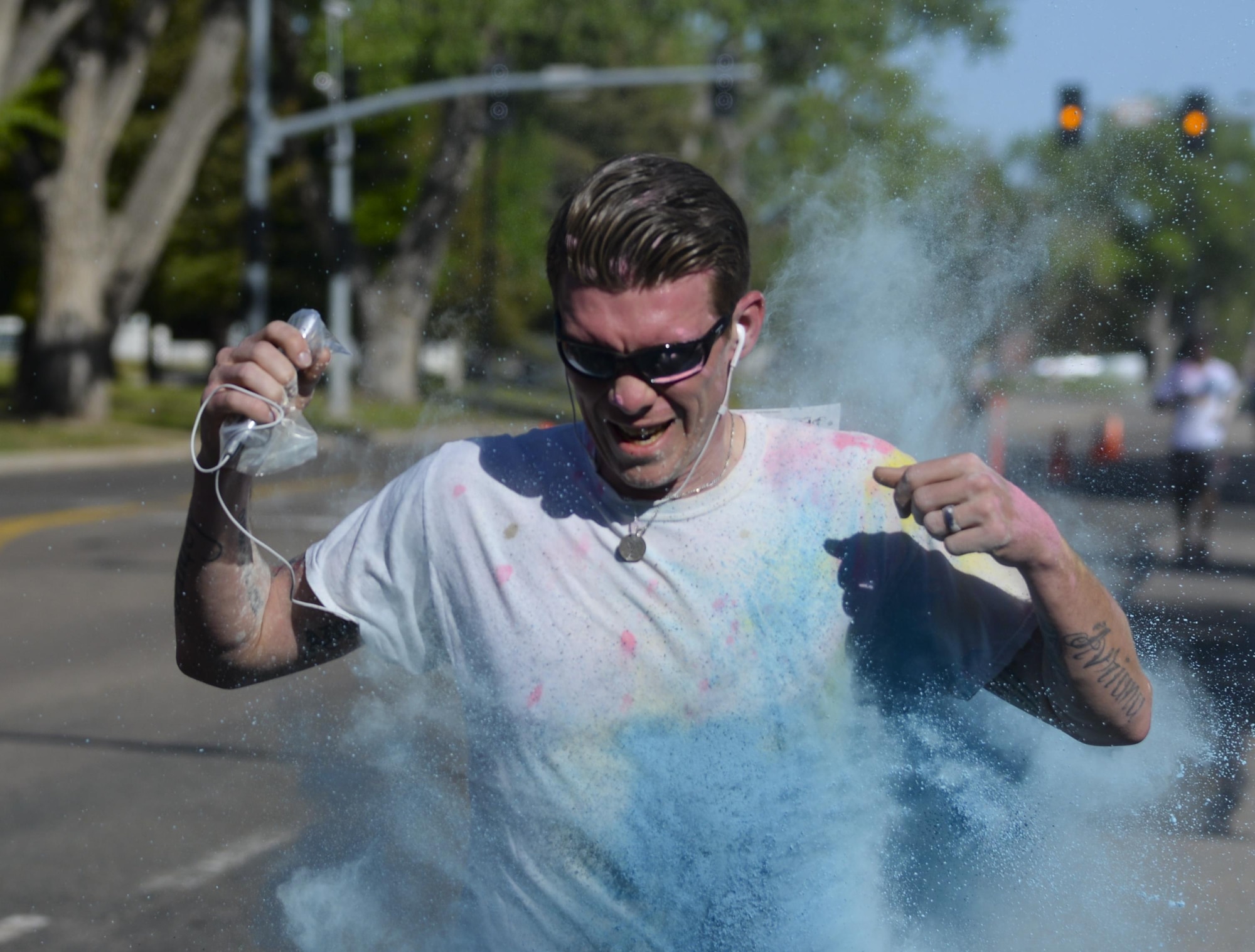 Staff Sgt. Andrew Leemasters, 90th Logistics Readiness Squadron, runs through a cloud of blue powdered chalk during the Air Force Sergeants Association Chapter 1178 Color Run on F.E. Warren Air Force Base, Wyo., June 4, 2016. Leemasters finished the 5K run first, with a time of 26 minutes 15 seconds. (U.S. Air Force photo by Senior Airman Jason Wiese)