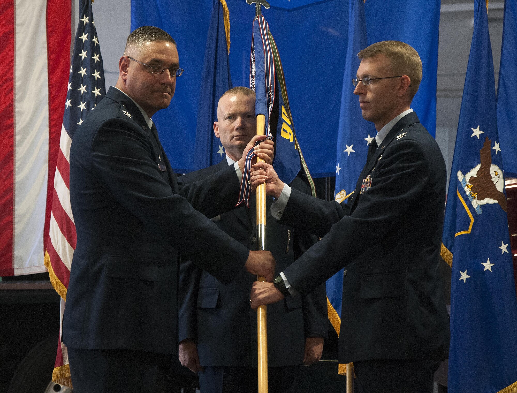 Col. Greg Buckner, 90th Maintenance Group commander, takes the 90th MXG guidon from Col. Stephen Kravitsky, 90th Missile Wing commander, during a change-of-command ceremony June 3, 3016, inside the Maintenance High Bay on F.E. Warren Air Force Base, Wyo. The passing of the guidon stems from military tradition, with the guidon symbolizing a flag that soldiers would rally behind during battles. (U.S. Air Force photo by Senior Airman Brandon Valle)