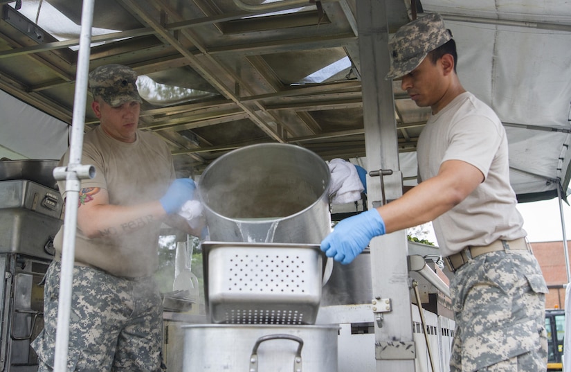 Sgt. Bishal Pandey and Spc. Zachary McDavid, culinary specialists assigned to the 200th Military Police Command drain a pot of pasta on their unit's Mobile Kitchen Trailer (MKT) in preparation for lunch during the unit’s battle assembly at Fort Meade, Maryland, on June 4, 2016. The command’s goal is to have each of its units become proficient with their MKT so when they have to mobilize they are ready and prepared to use it.  (U.S. Army photo by Spc. Stephanie Ramirez)