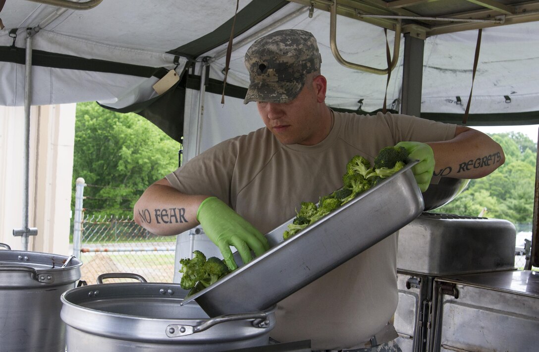 Spc. Zachary McDavid, a culinary specialist assigned to the 200th Military Police Command, prepares lunch on the unit's Mobile Kitchen Trailer (MKT) during battle assembly at Fort Meade, Maryland, on June 4, 2016. The command’s goal is to have each of its units become proficient with their MKT so when they have to mobilize they are ready and prepared to use it.  (U.S. Army photo by Spc. Stephanie Ramirez) 