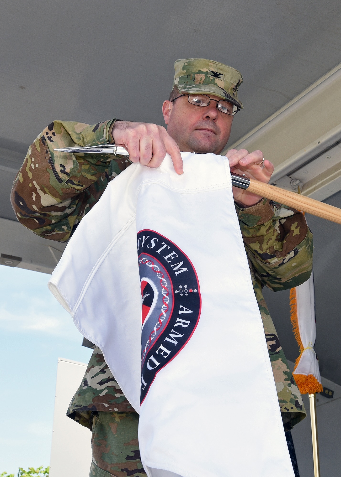 Army Col. Ladd Tremaine, Armed Forces Medical Examiner System director, changes the official seal of AFMES during an unveiling ceremony May 26, 2016, at AFMES on Dover Air Force Base, Del. This marks a significant event in AFMES history. (U.S. Navy photo/Mass Communication Specialist 3rd Class Jonteil Johnson)
