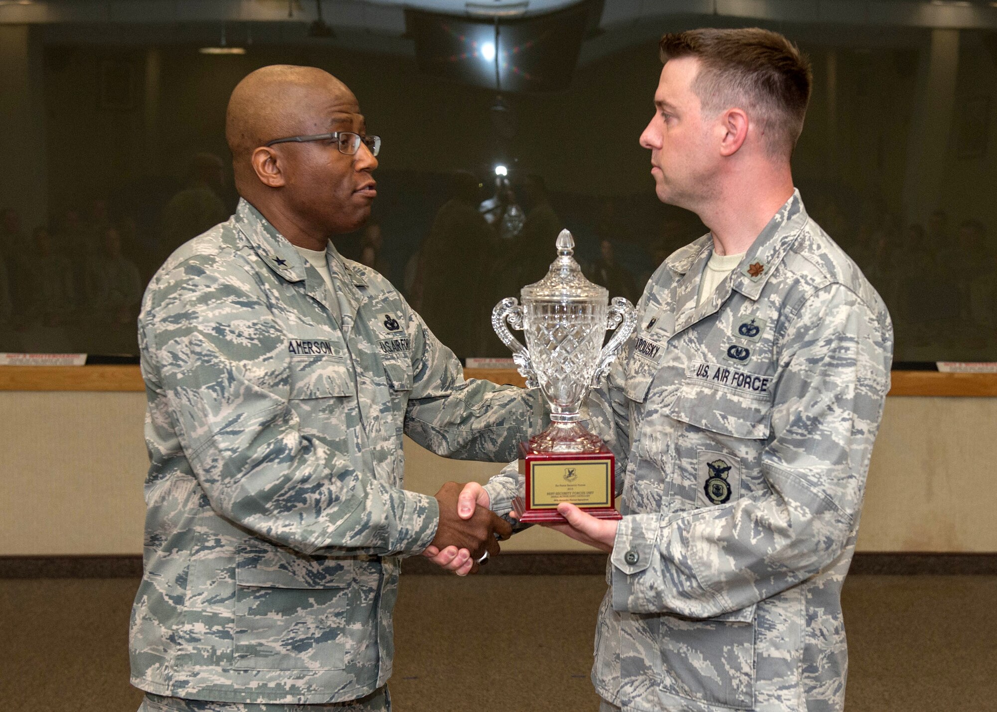 Brig. Gen. Allen Jamerson, Headquarters U.S. Air Force director of Security Forces, presents Maj. Joseph Bincarousky, 66th Security Forces Squadron commander, with the Air Force Outstanding Security Forces Small Unit award during a ceremony at the base conference center June 3. This is the third time in the last four years that the unit has won this award. (U.S. Air Force photo by Jerry Saslav)
