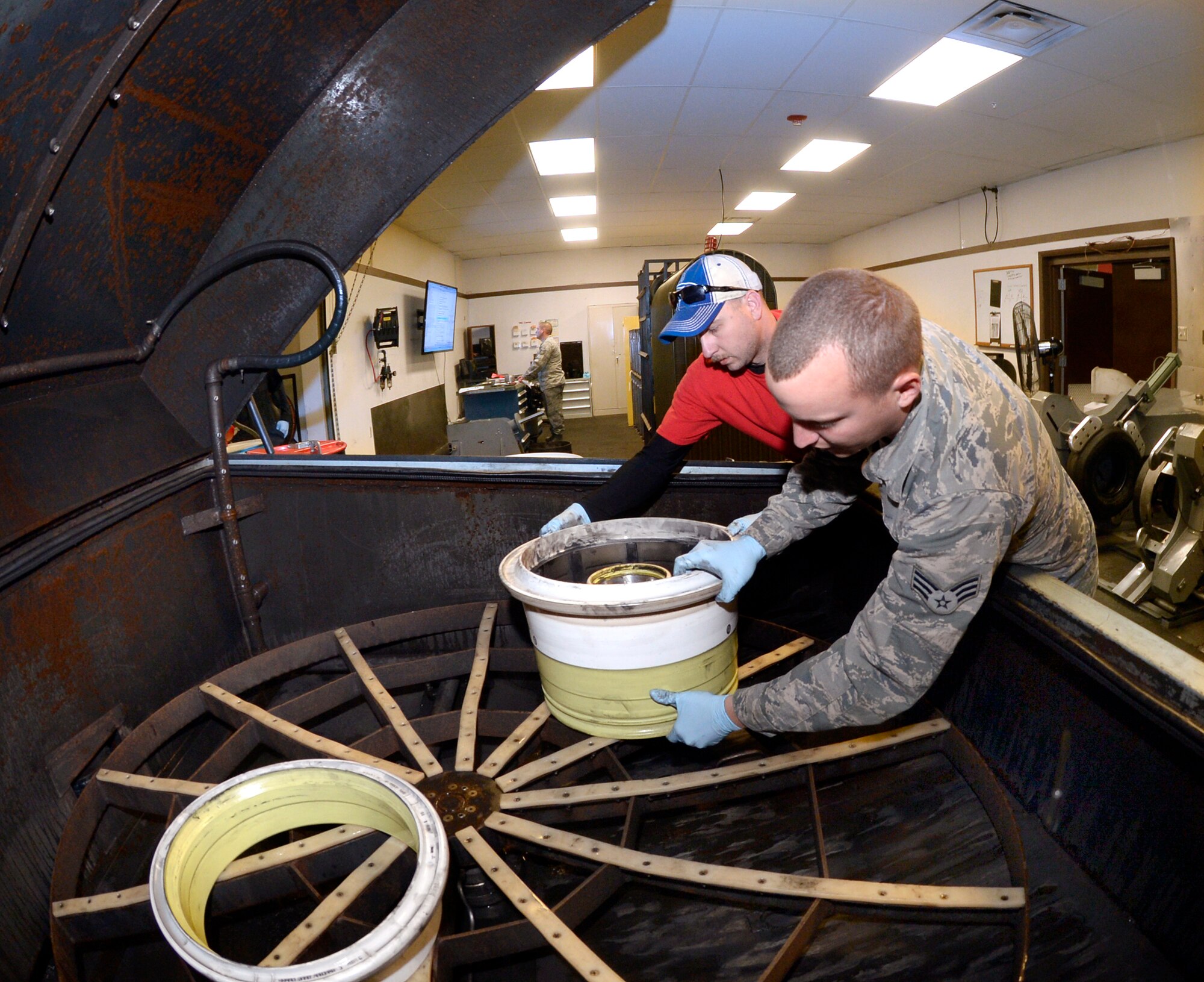 Tech. Sgt. James Speicher, an Air Reserve Technician with the 419th Maintenance Squadron, and Senior Airman Joseph Sprowls, 388th Maintenance Squadron, load F-35 wheels into a parts washer May 20, 2016, at Hill Air Force Base, Utah. (U.S. Air Force photo by Todd Cromar)