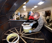 Tech. Sgt. James Speicher, an Air Reserve Technician with the 419th Maintenance Squadron, and Senior Airman Joseph Sprowls, 388th Maintenance Squadron, load F-35 wheels into a parts washer May 20, 2016, at Hill Air Force Base, Utah. (U.S. Air Force photo by Todd Cromar)