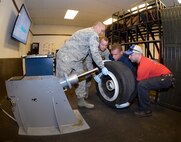 From the left, Tech. Sgt. Astolfo Mercado Cruz, Senior Airman Joseph Sprowls, and Senior Airman Linwood Harrison, all three from the 388th Maintenance Squadron, and Tech. Sgt. James Speicher, an Air Reserve Technician from the 419th Maintenance Squadron, lift an F-35 wheel onto a manually-operated tire changing machine at Hill Air Force Base, Utah, May 20, 2016. (U.S. Air Force photo by Todd Cromar)
