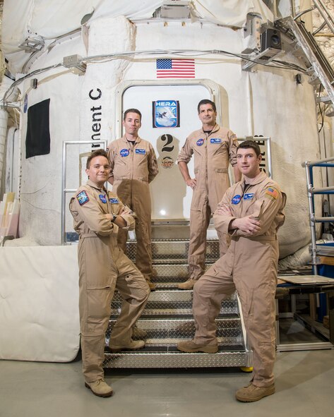 Crew members for the NASA Human Exploration Research Analog simulation mission stand in front of the habitat for program. HERA is a high-fidelity mission simulation environment operated by NASA’s Human Research Program at the Johnson Space Center, Texas. HERA missions provide the operational setting for important HRP research aimed at reducing the risks to astronauts on future space exploration missions beyond low Earth orbit. HERA X “launched” on May 2 for a 30-day mission to the near-Earth asteroid “Geographos.” The four crew members are (left to right): Chris Matty of Houston, Texas; Oscar Mathews of Virginia Beach, Va.; Ron Franco of Lockport, N.Y.; and Casey Stedman of Olympia, Wash. (NASA Photo)