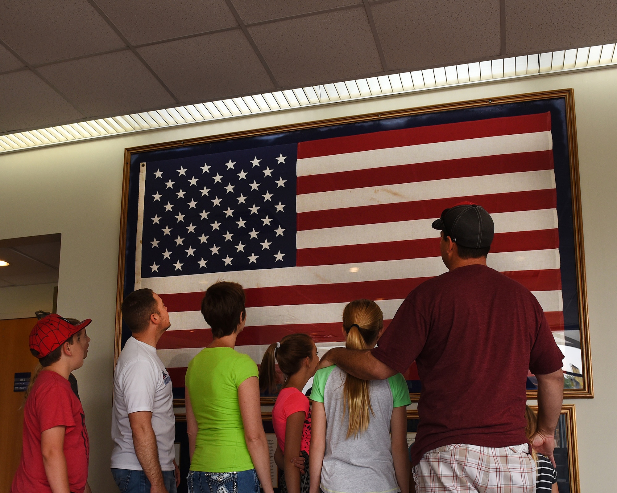 Master Sgt. Kelly K. Collett, broadcast manager, thrid from left, and his family take a tour of the TEC TV studios June 6, 2016, at the I.G. Brown Training and Education Center in Louisville, Tenn., to include the American flag display in Spruance Hall. The flag was last flown on campus July 29, 1986, after a 16-year journey over the capitols of every state and territory in the United States. (U.S. Air National Guard  photo by Master sgt. Mike R. Smith/released)  