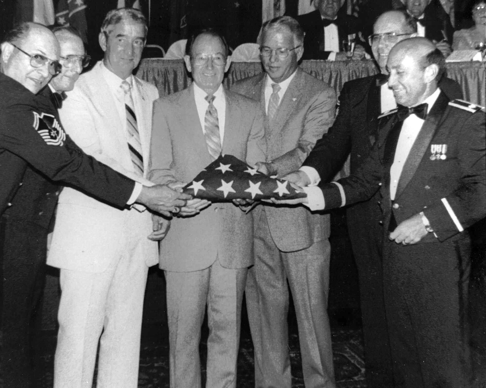 From left, Chief Master Sgt. Myron Pigg, Senior Master Sgt. Jimmie Stewart, Chief Master Sgt. Jim Laux, Chief Master Sgt. Paul Lankford, Col. Edmund Morrisey, Chief Master Sgt. Gordon Kniskern, and Col. Larry Martin commemorate the return of the American flag, July 24, 1986, at the I.G. Brown Training and Education Center in Louisville, Tenn., nearly 16 years to the month after it was sent out by NCO academy class 71-1 to fly over every state and territory of the United States. The flag was last flown July 29, 1986, at the first reveille of NCO academy class 86-3. Thousands of Airmen have seen the flag on display in Spruance Hall during the 30 years since. (U.S. Air National Guard file photo/released)  