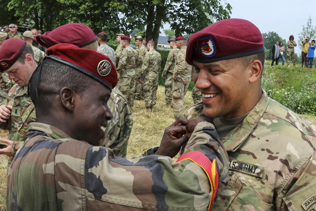 U.S. and French paratroopers exchange wings after 320 soldiers from three countries, including Germany, jumped into Saint Mere Eglise, France, June 5, 2016, to commemorate the 72nd anniversary of D-Day. The U.S. soldiers are assigned to the 82nd Airborne Division. Army photo by Capt. Joe Bush