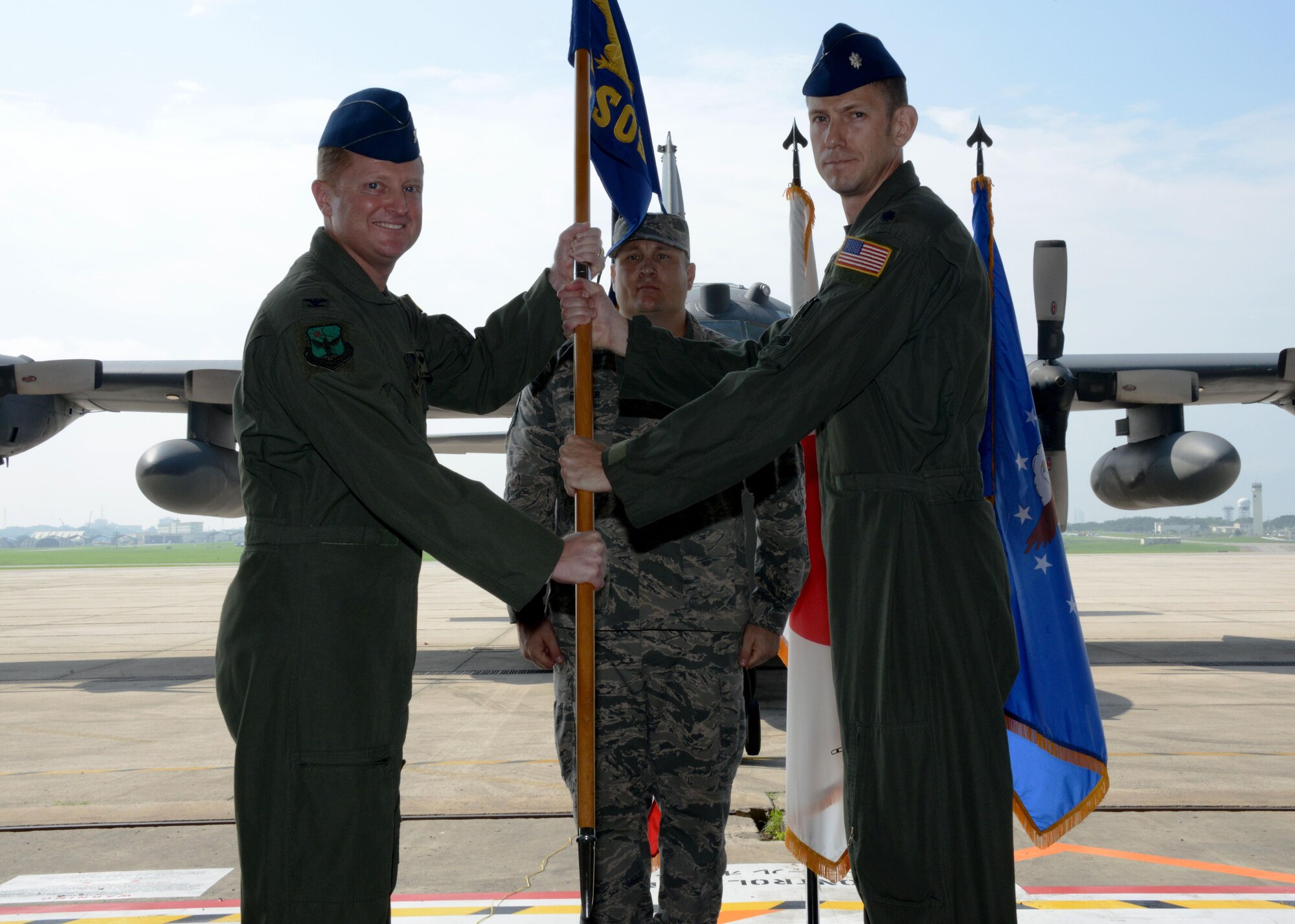 U.S. Air Force Col. William Freeman, 353rd Special Operations Group commander, passes the guidon to U.S. Air Force Lt. Col. David Lucas, 1st Special Operations Squadron commander, during the 1st SOS change of command on Kadena Air Base, Japan, June 6, 2016. The passing of the guidon is the exact moment that the new commander officially takes responsibility of the new unit. The 1st SOS operates the MC-130H Combat Talon II aircraft in support of joint and allied special operations forces.  (U.S. Air Force photo by Master Sgt. Kristine Dreyer)
