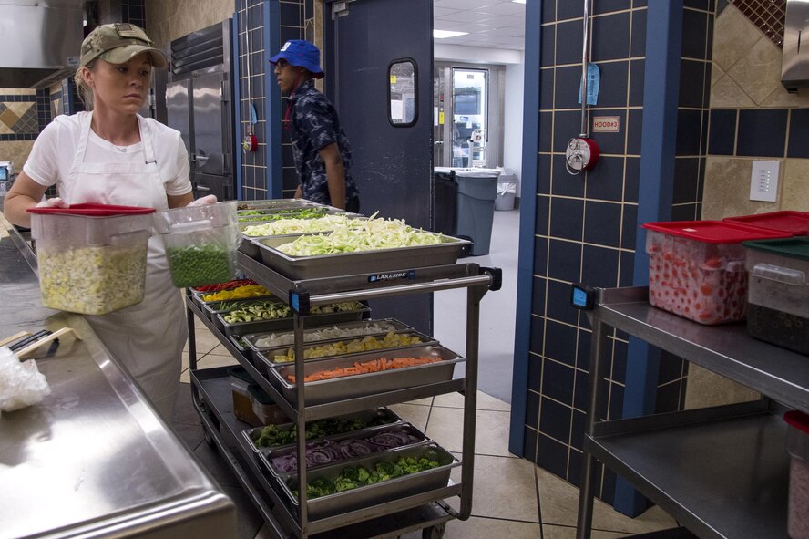 U.S. Air Force Staff Sgt. Rebecca Young, 23d Force Support Squadron shift leader specialist, prepares her team’s serving line during a Top Chef Competition June 3, 2016, at Moody Air Force Base, Ga. Young’s team served Mongolian BBQ with an option of vegetables and chicken, beef, or shrimp as their protein. (U.S. Air Force photo by Airman 1st Class Janiqua P. Robinson/Released)