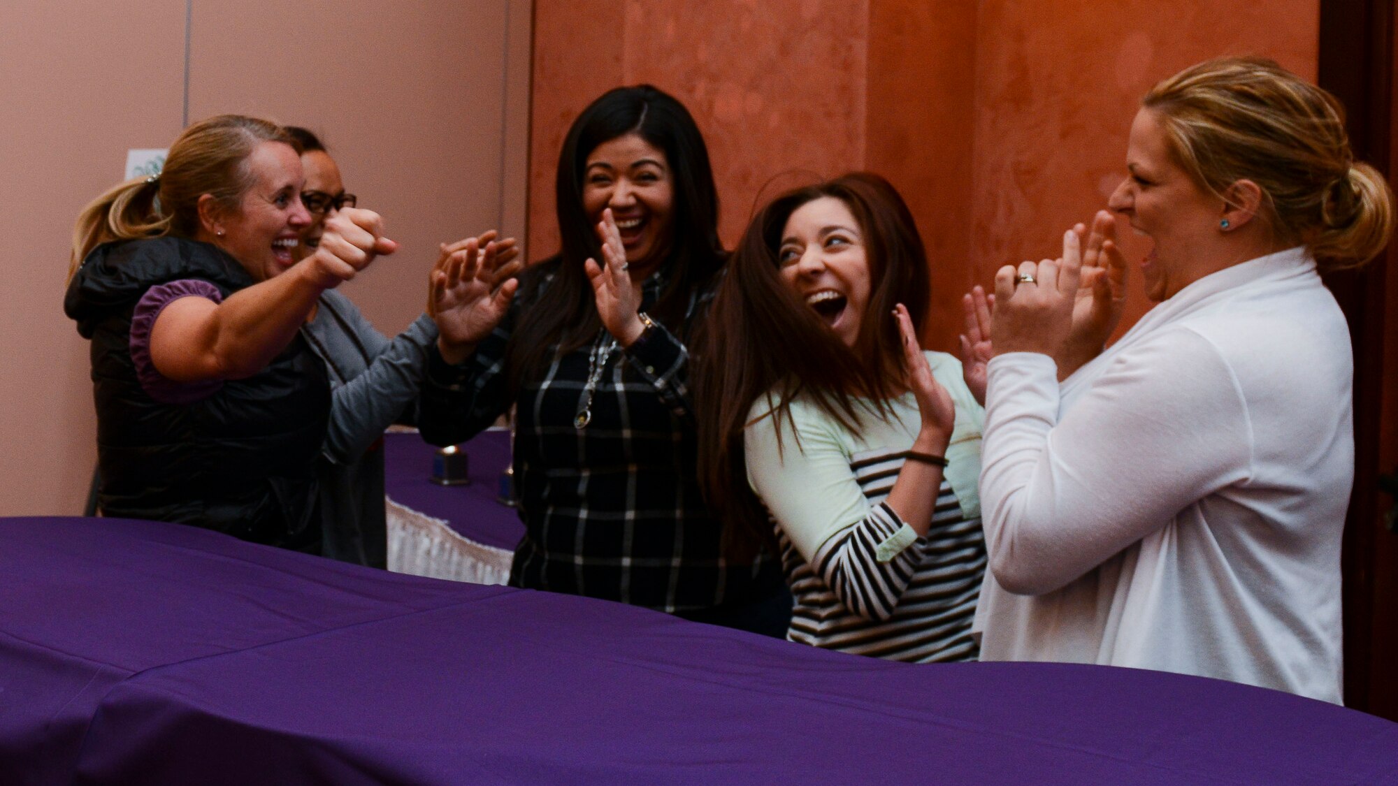 Spouses from the 31st Mission Support Group celebrate after answering a question correctly during the second quarter “Spouse It Up: Family Feud” competition, June 2, 2016, at Aviano Air Base, Italy. The 31st MSG team won the competition. (U.S. Air Force photo by Senior Airman Austin Harvill/Released)