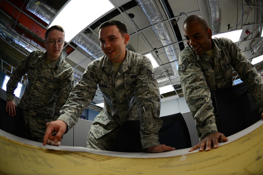 Airman 1st Class David Young, Staff Sgt’s Patrick Hartigan and Jospeh Allen, 2nd Civil Engineer Squadron technical support Airmen, review building schematics at Barksdale Air Force Base, La., June 1, 2016. Technical support Airmen also provide digging permits which are required to start a construction project. (U.S. Air Force photo/Senior Airman Luke Hill)